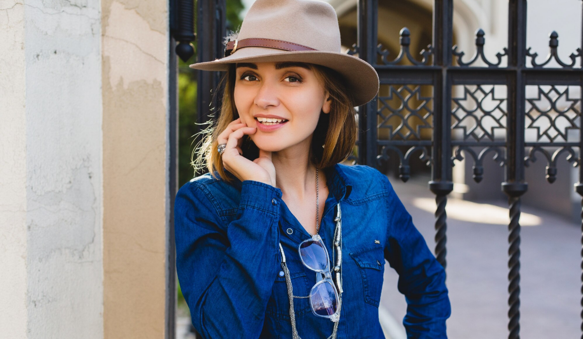 Woman in a relaxed, confident outfit taking a moment before writing her dating profile bio